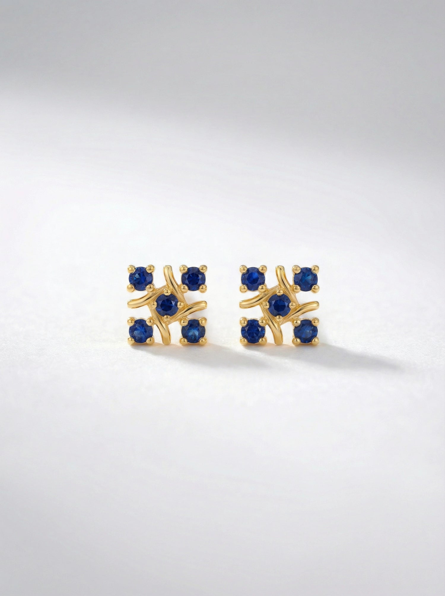 `8k Gold plated earrings with blue gemstones on a light gray background
