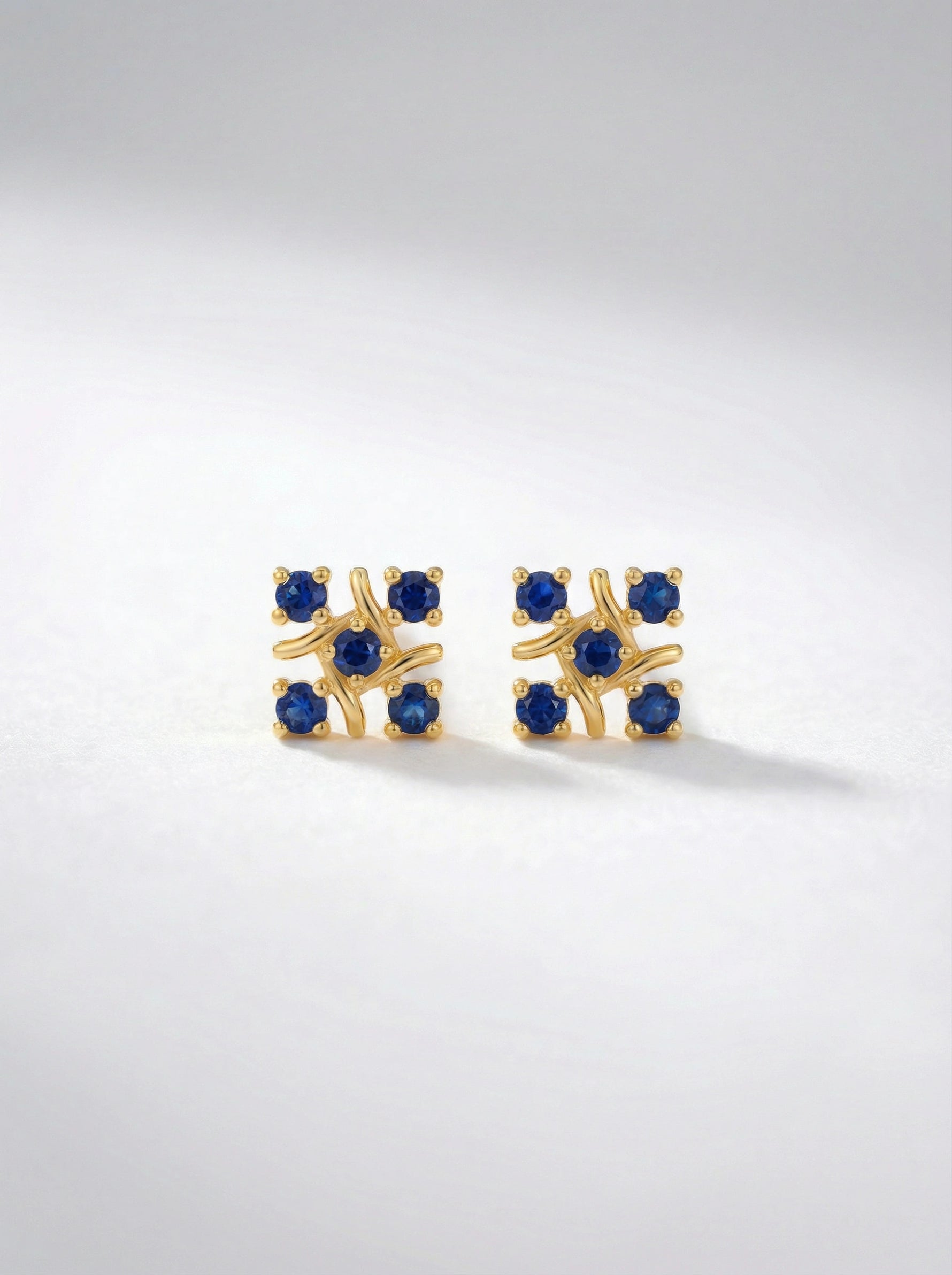 `8k Gold plated earrings with blue gemstones on a light gray background