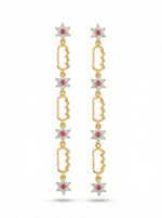 18k Gold plated earrings with star-shaped elements and red gemstones on a white background