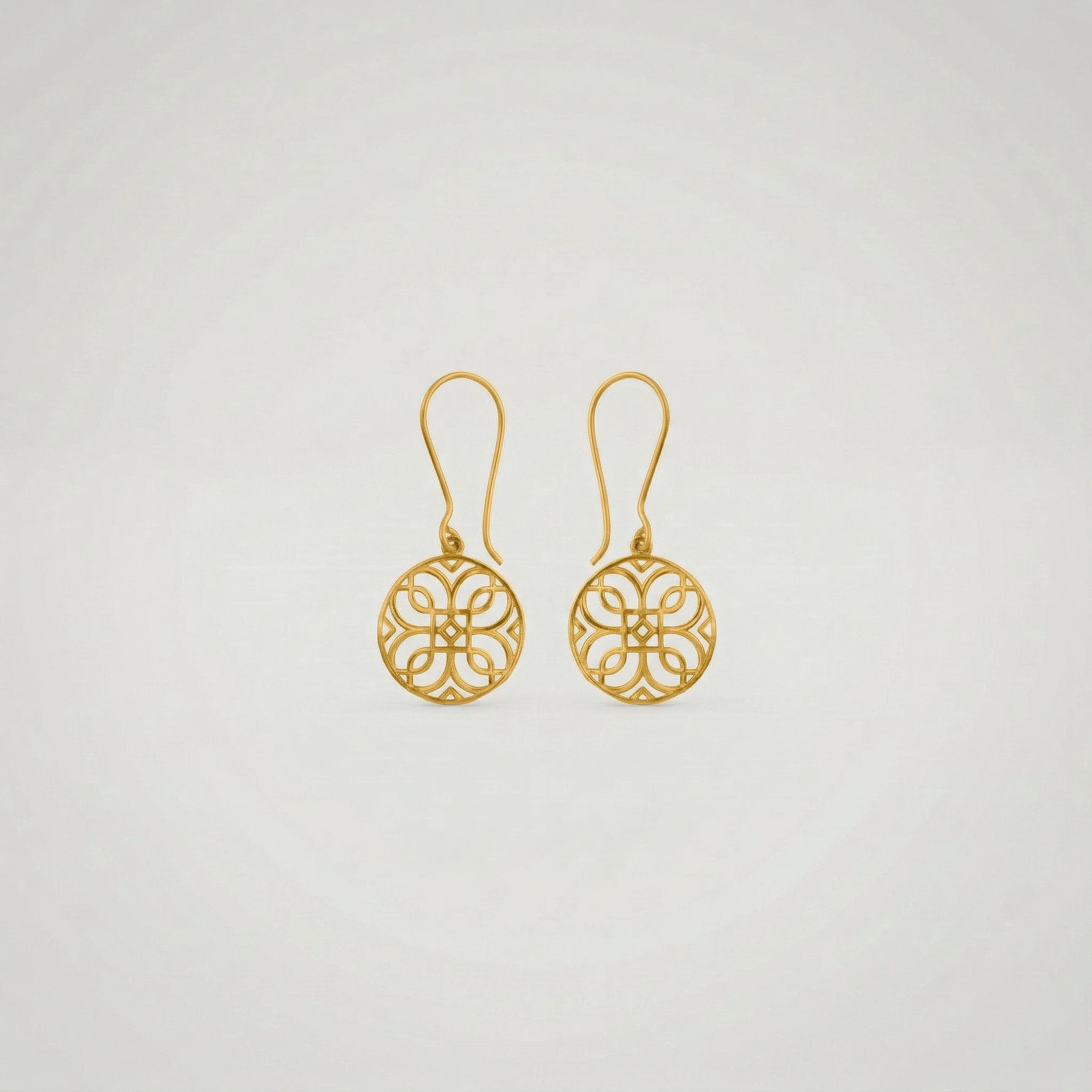 Pair of 18k gold plated earrings on a light gray background