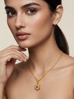 Woman wearing a 18k gold plated necklace with a floral pendant on a beige background