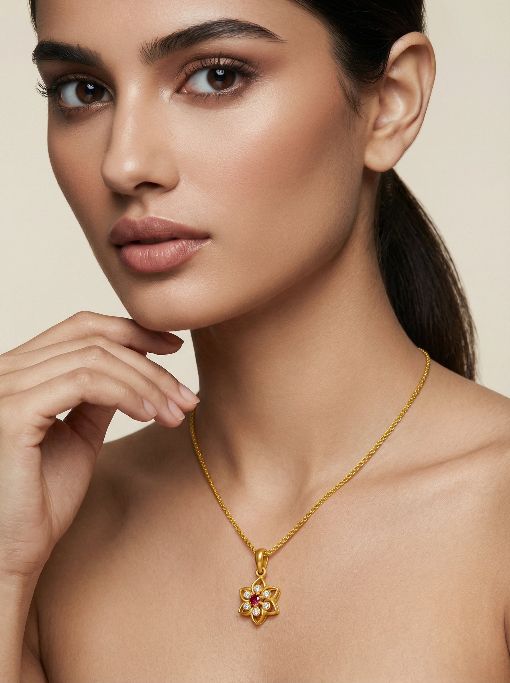 Woman wearing a 18k gold plated necklace with a floral pendant on a beige background