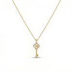 18k Gold  plated  key-shaped pendant on a chain against a white background