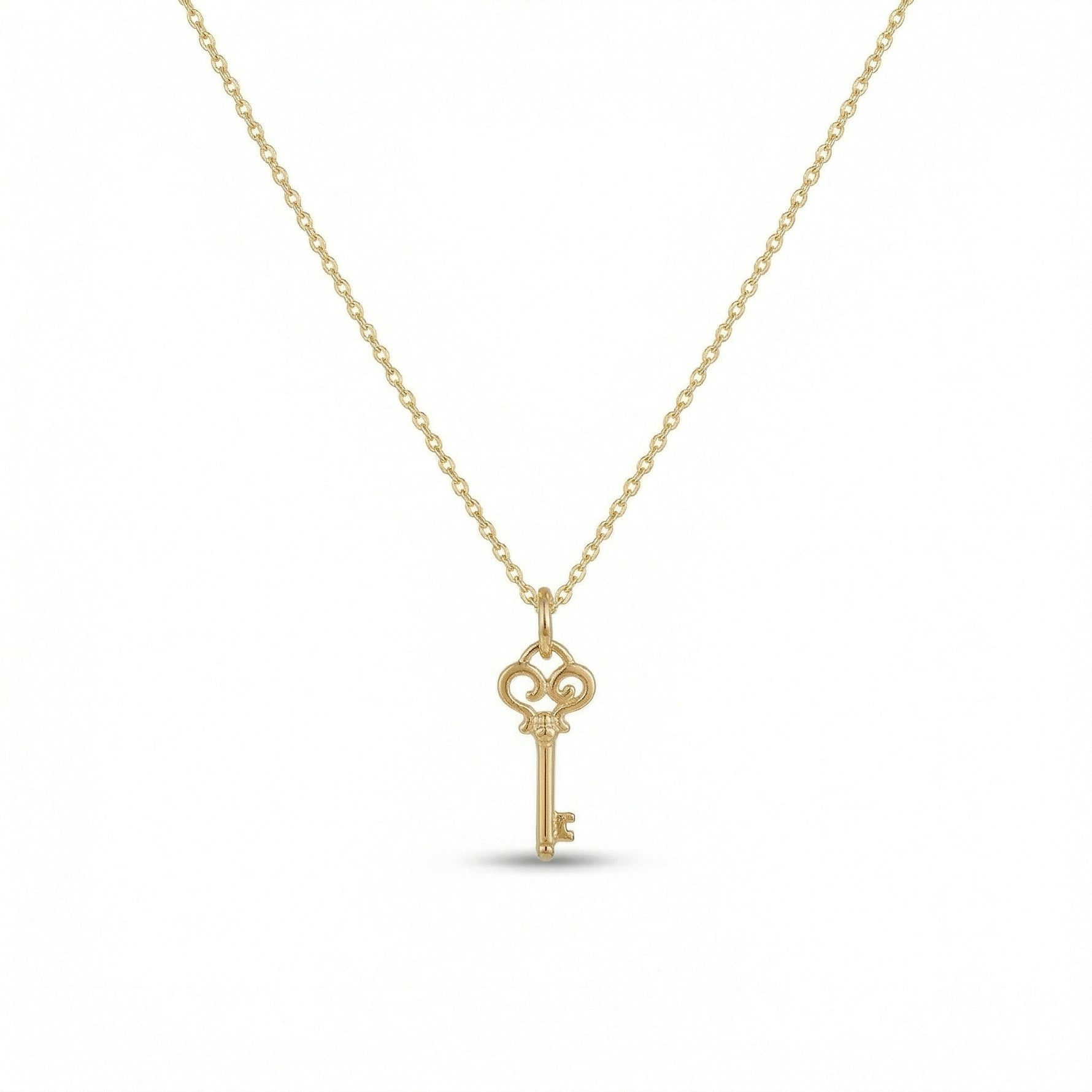 18k Gold  plated  key-shaped pendant on a chain against a white background