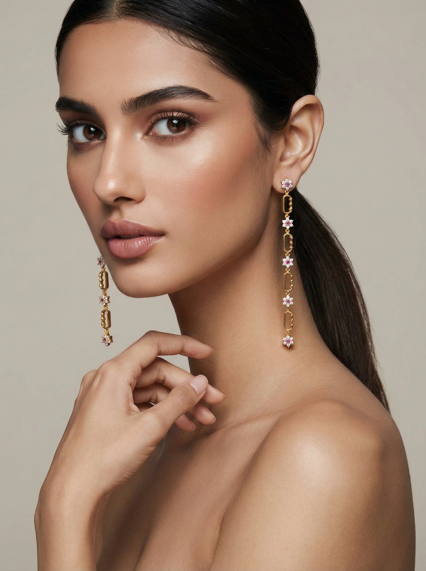Woman wearing 18k gold plated earrings with a neutral background