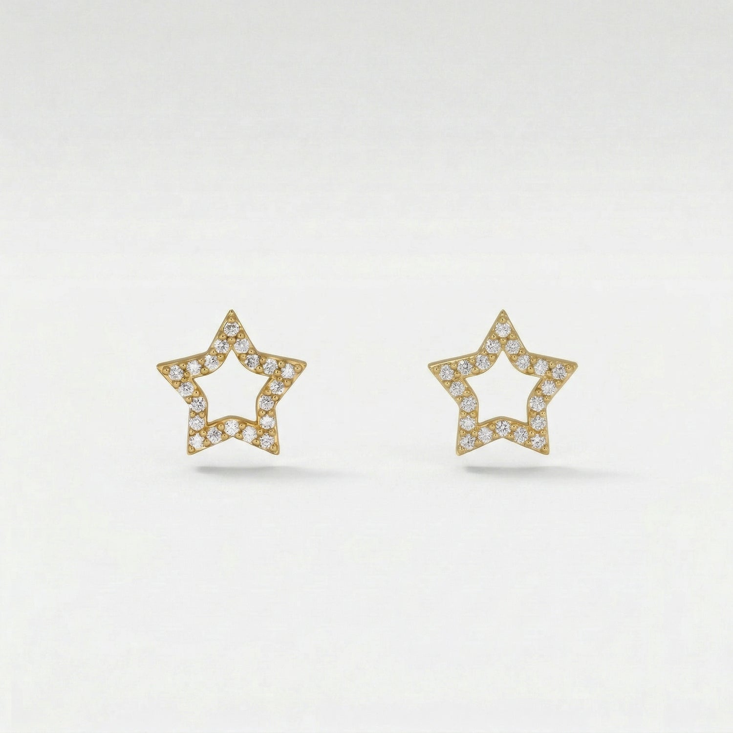 Star-shaped 18k gold plated earrings with diamond accents on a light gray background