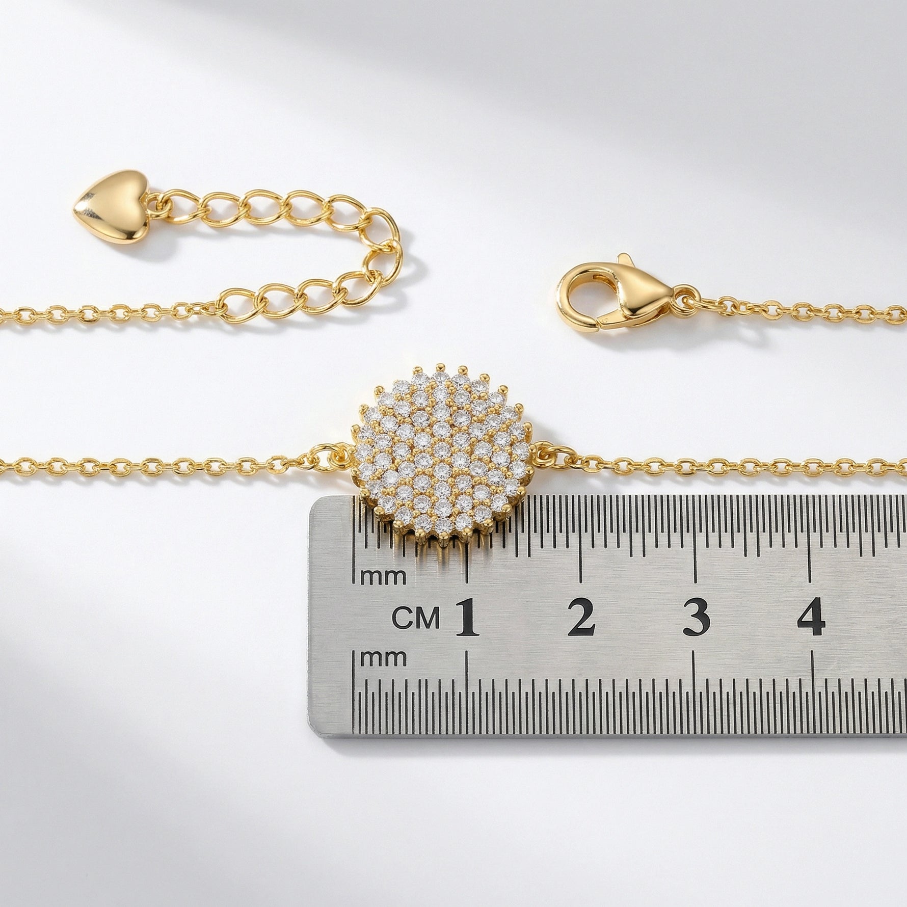 18k Gold plated bracelet with a decorative clasp on a ruler for size reference