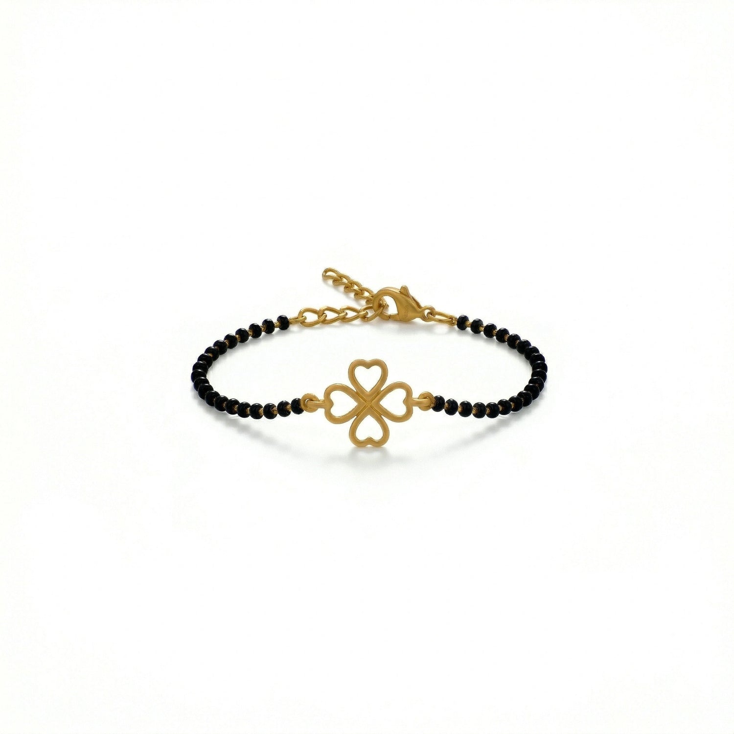 Gold bracelet with black beads and clover charm on a white background