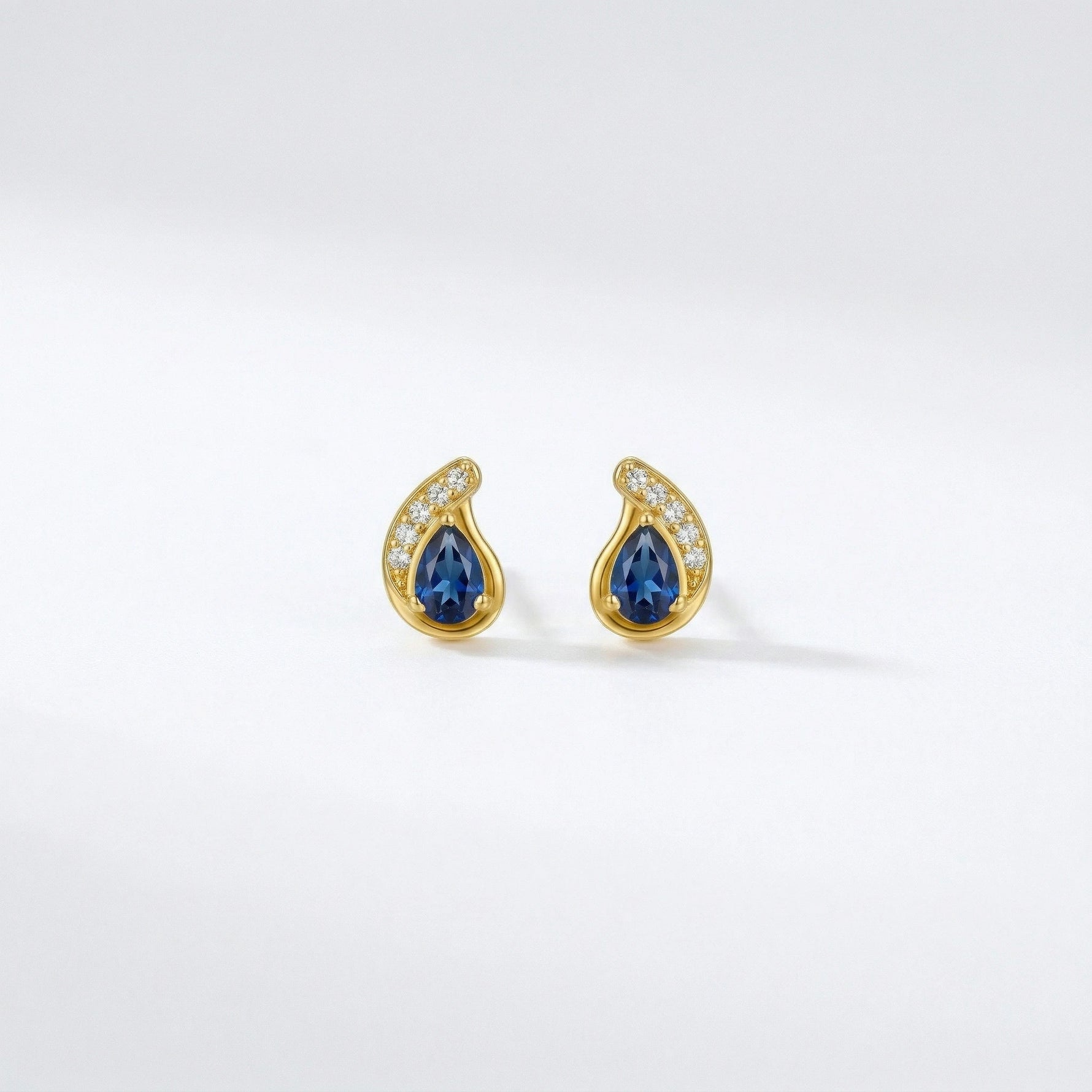 18k Gold plated earrings with blue gemstones on a white background