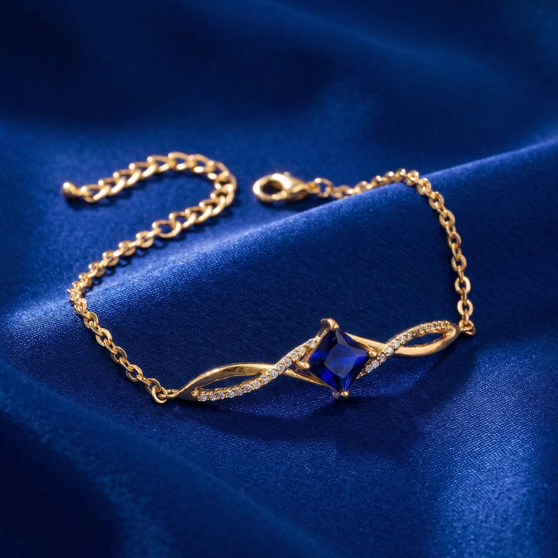 18k Gold Plated bracelet with a blue gemstone on a blue fabric background