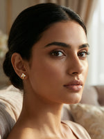 Woman wearing a 18k  gold plated earring in a softly lit room