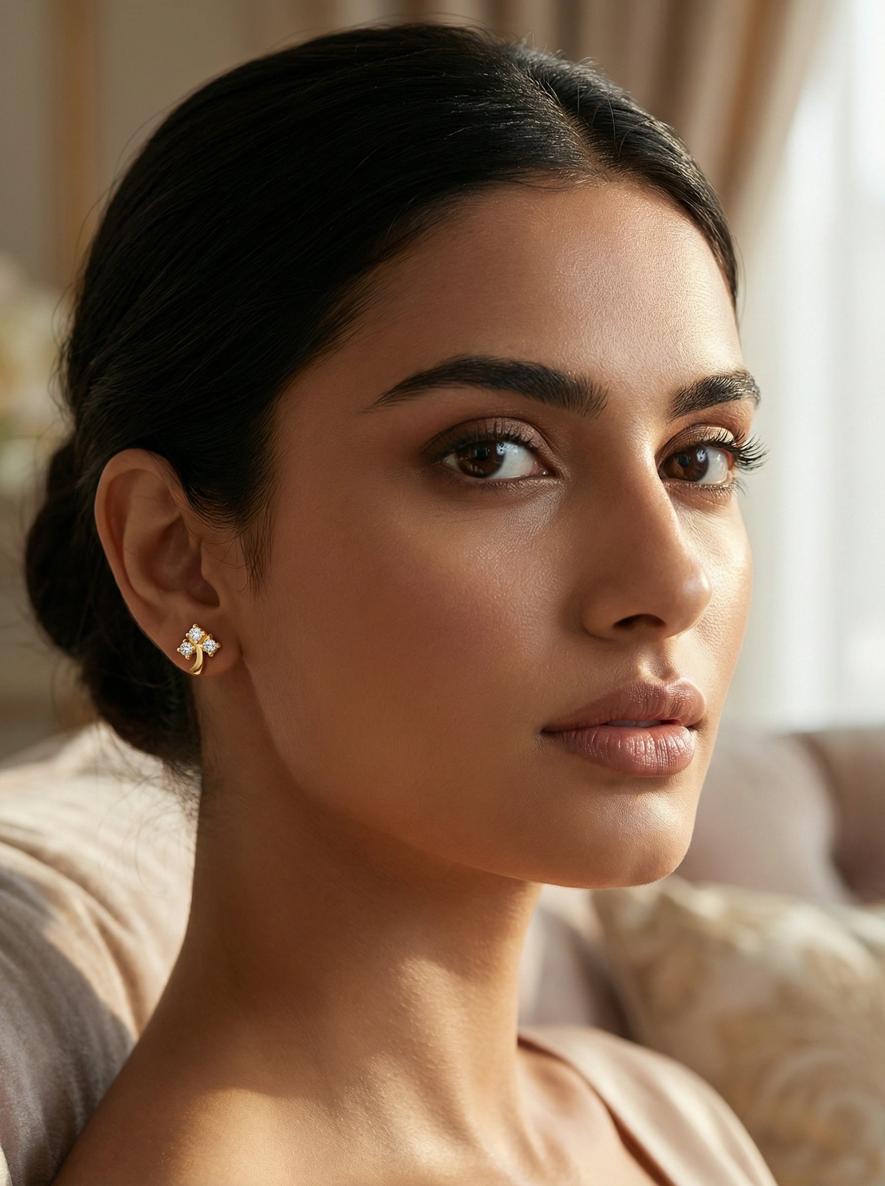 Woman wearing a 18k  gold plated earring in a softly lit room