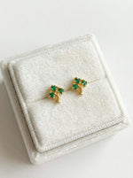 18k Gold plated earrings with green gemstones on a white jewelry box