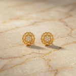 Pair of 18k gold plated earrings with diamond accents on a marble surface