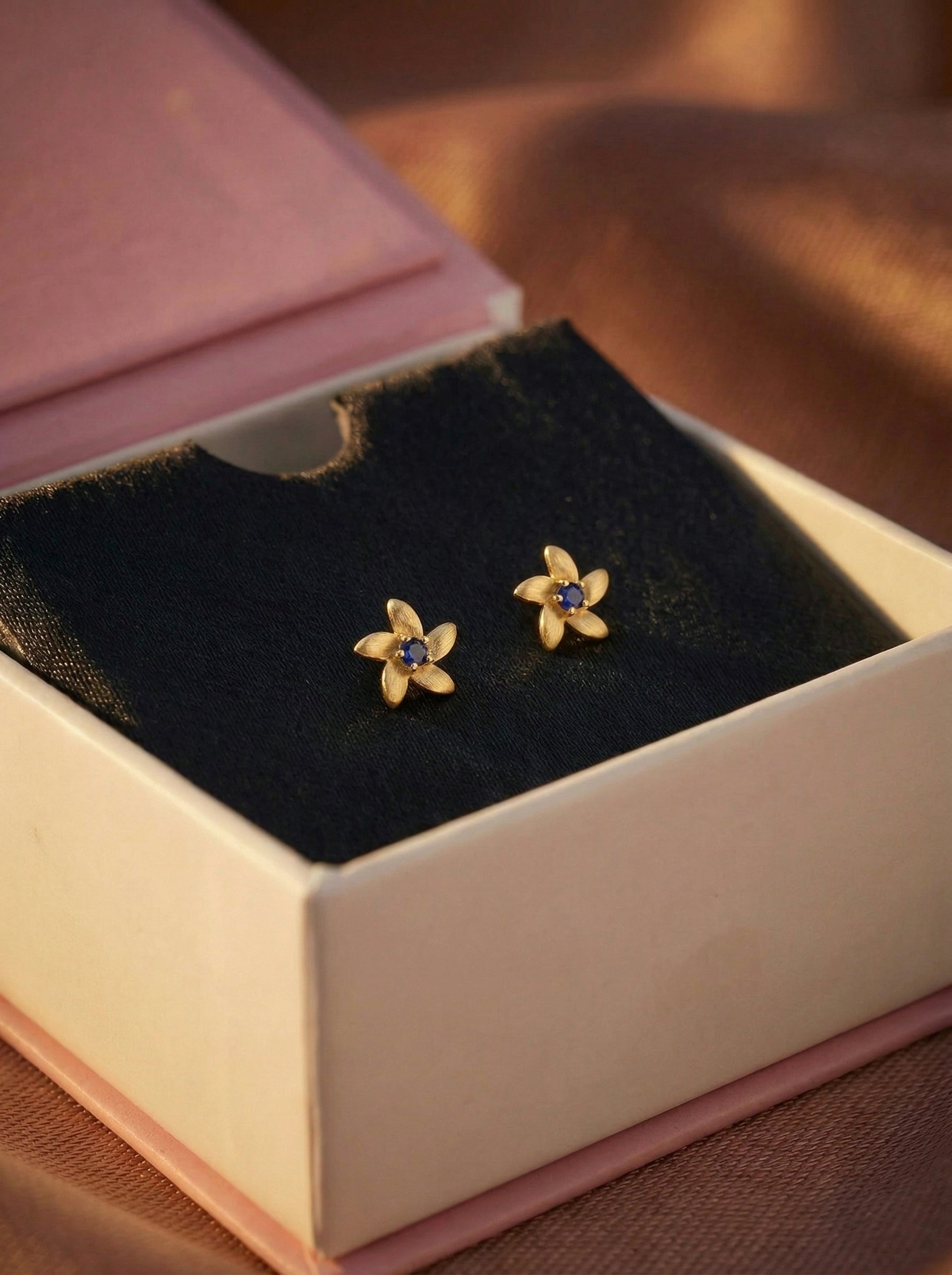 18k Gold plated  flower-shaped earrings with gemstones in a jewelry box.