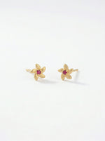 18k Gold plated flower-shaped earrings with red gemstones on a white background