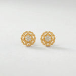 Pair of 18k gold plated earrings with diamond accents on a light gray background