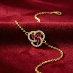 18k Gold plated bracelet with gemstones on a red fabric background