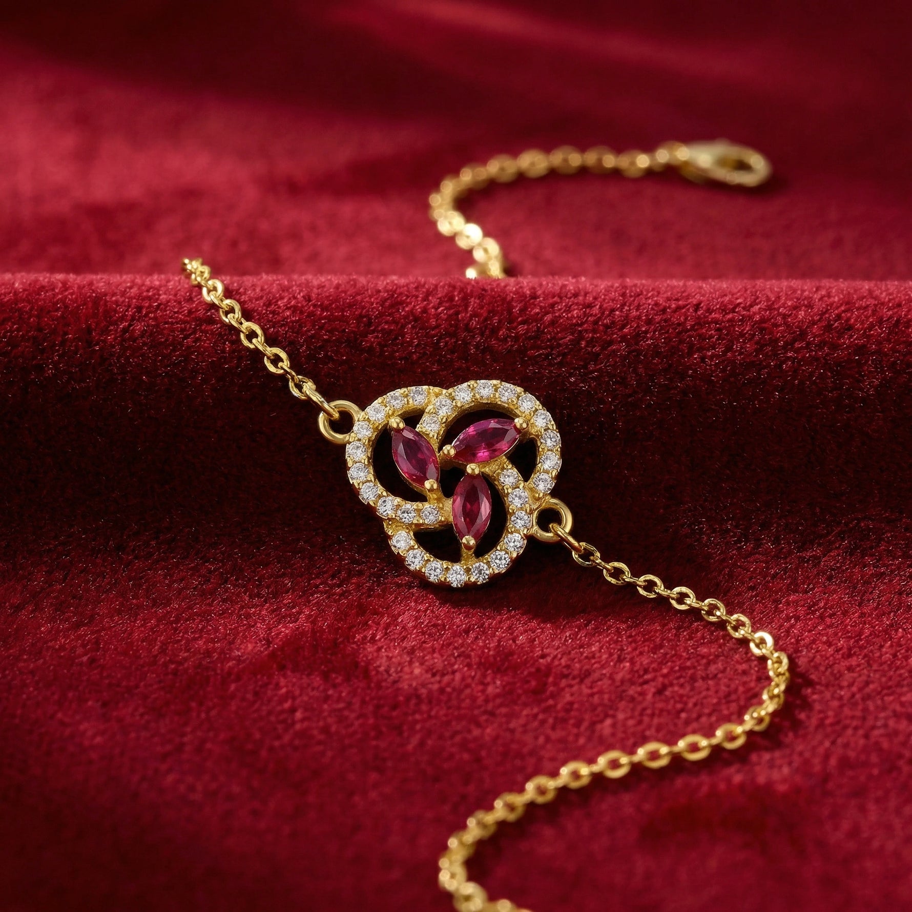 18k Gold plated bracelet with gemstones on a red fabric background