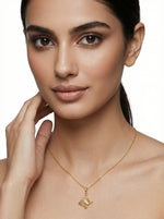 Woman wearing a 18k gold plated necklace with a butterfly pendant on a neutral background
