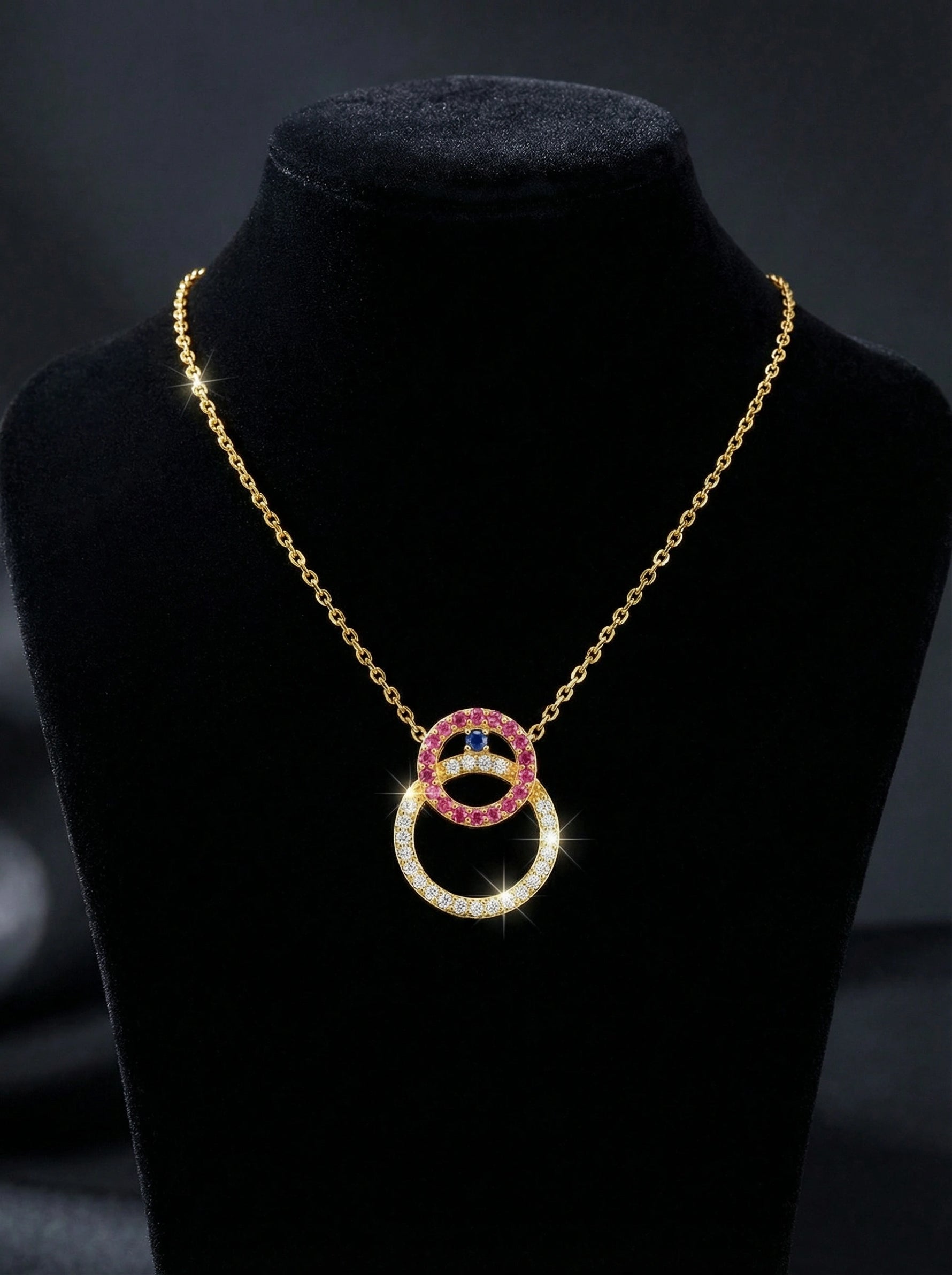 18k gold plated Necklace with interlocking rings on a black stand against a dark background