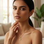 Woman wearing a 18k  gold plated necklace with a blurred indoor background