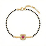 18k Gold plated bracelet with black beads and a central pink gemstone on a white background