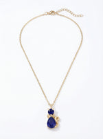 18k gold plated Gold necklace with a blue teardrop pendant on a white background