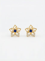 Pair of 18k gold plated earrings with blue gemstones on a white background
