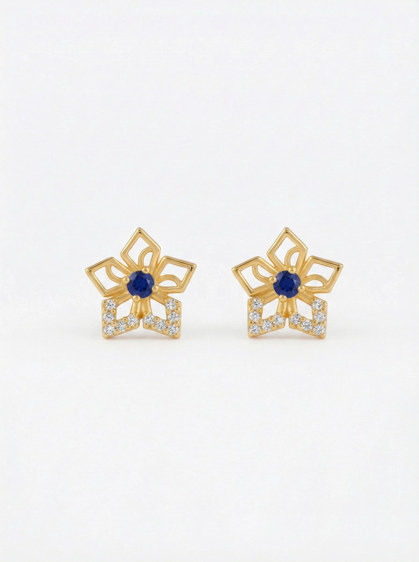 Pair of 18k gold plated earrings with blue gemstones on a white background