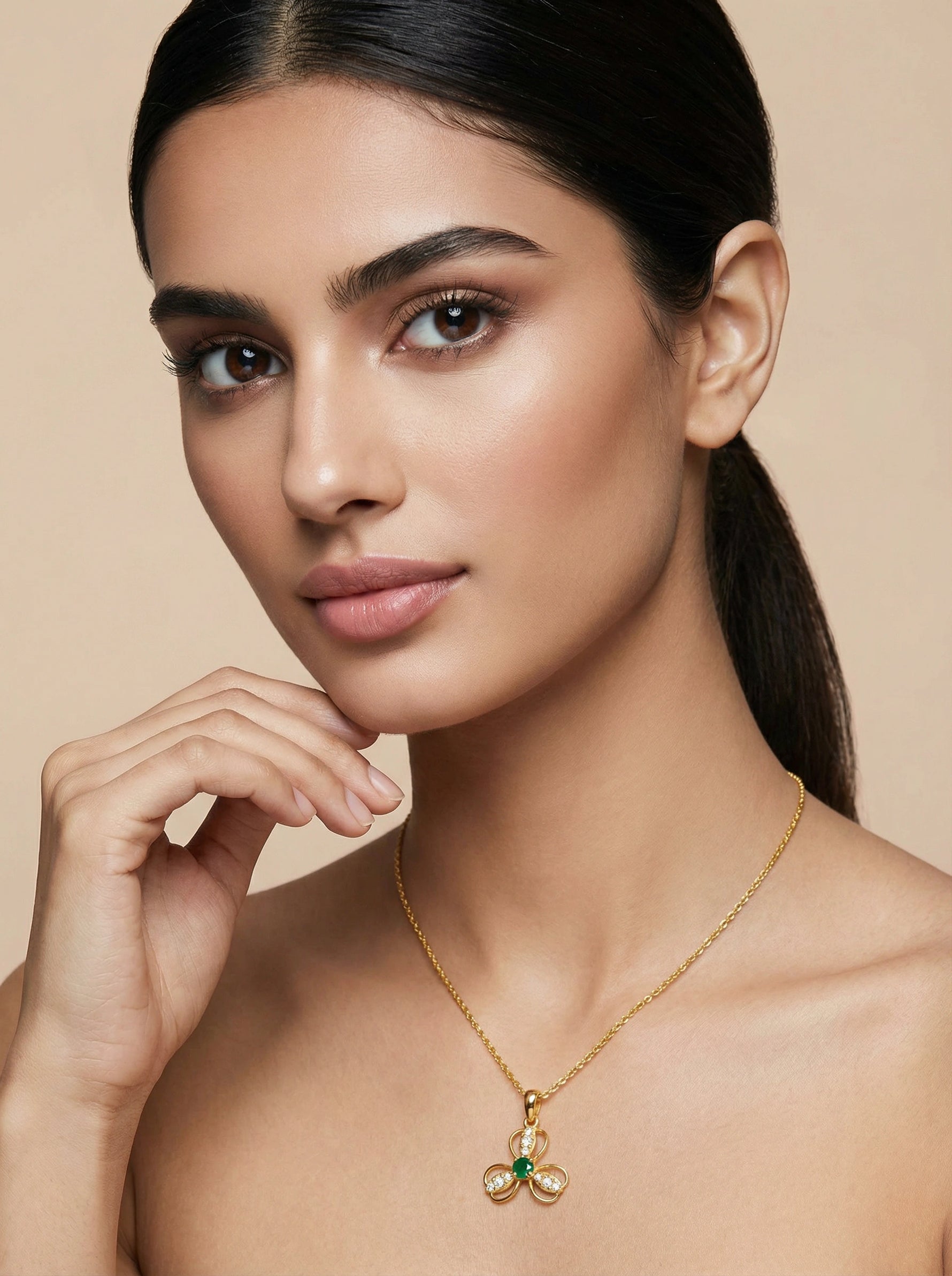 Woman wearing a 18k gold plated necklace with a pendant against a beige background