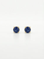 Pair of 18k gold plated earrings with blue gemstones on a white background