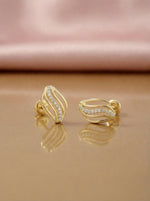 18k Gold plated earrings with diamond accents on a reflective surface