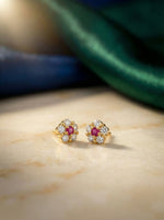 18k gold plater earrings with red gemstones on a marble surface