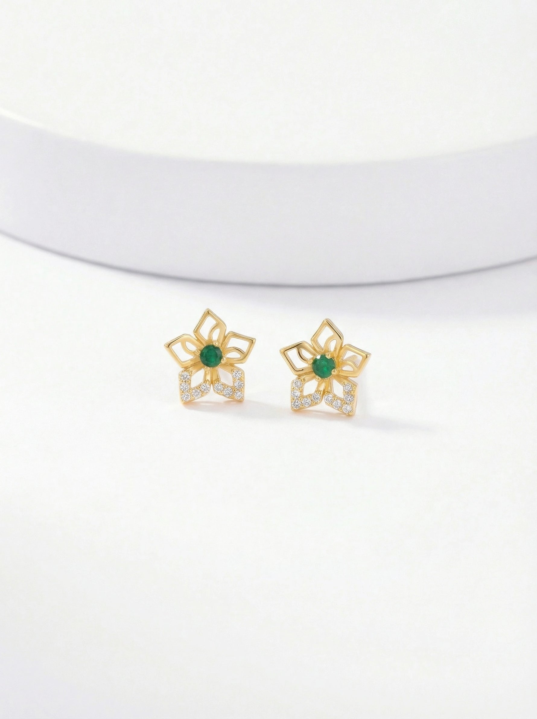 Pair of 18k gold plated earrings with green gemstones on a white background 