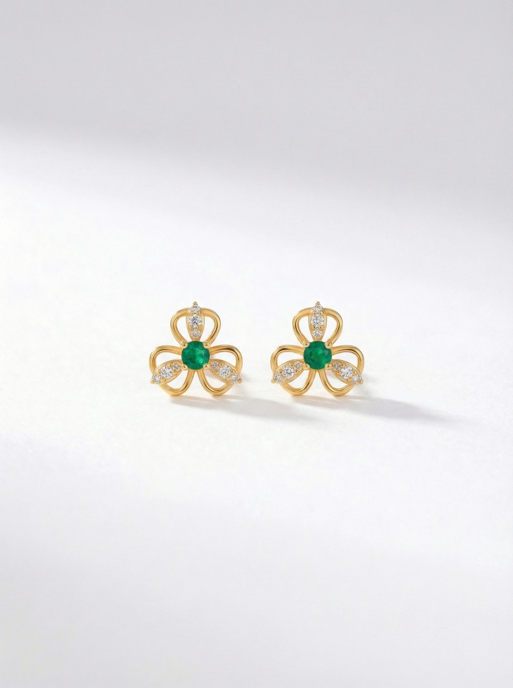 18k Gold plated earrings with green gemstones on a white background