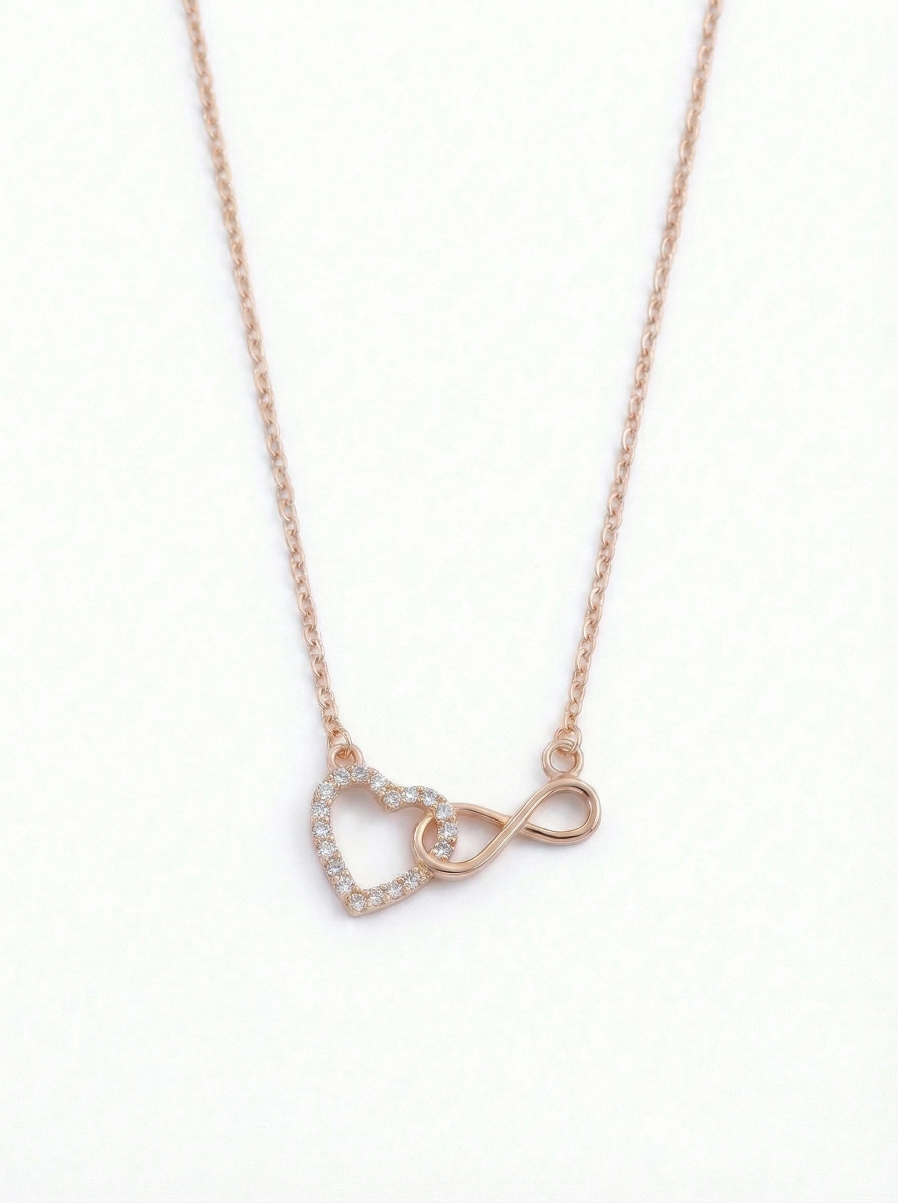  18k rose gold plated necklace with heart and infinity symbol pendant on a white background