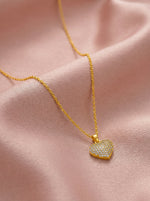 18k Gold plated heart-shaped pendant necklace on a pink fabric background