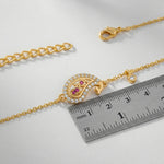 18k Gold plated bracelet with a decorative clasp and gemstones next to a ruler on a light gray background