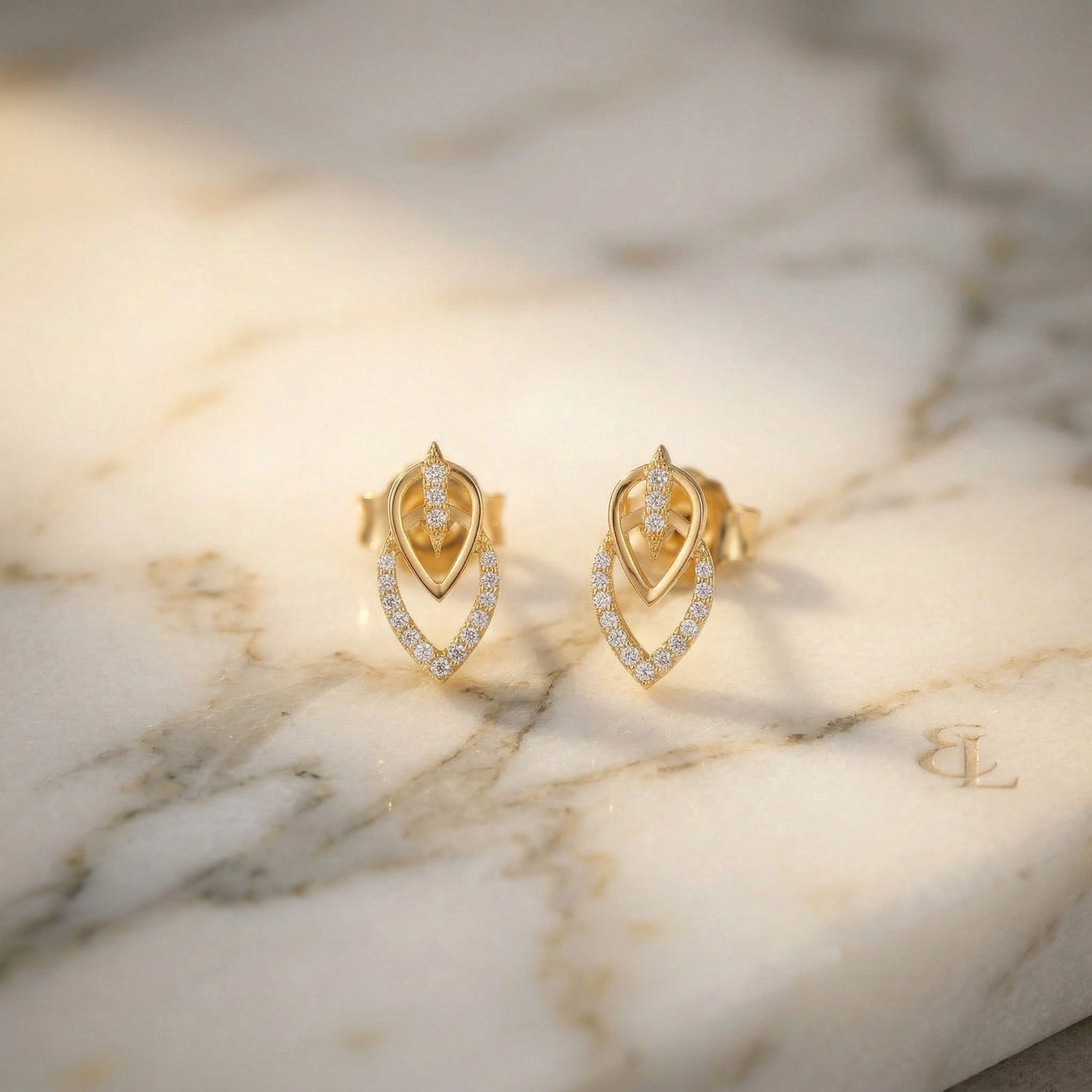 18k Gold plated earrings with diamond accents on a marble surface