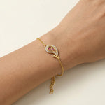 18k Gold plated bracelet with a heart-shaped gemstone on a wrist against a light background