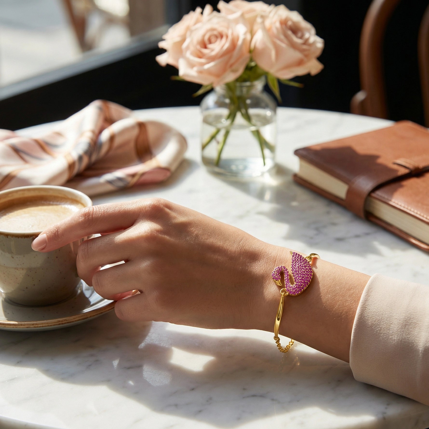 18k Gold plated bracelet with pink gemstones on a person's wrist against a neutral background