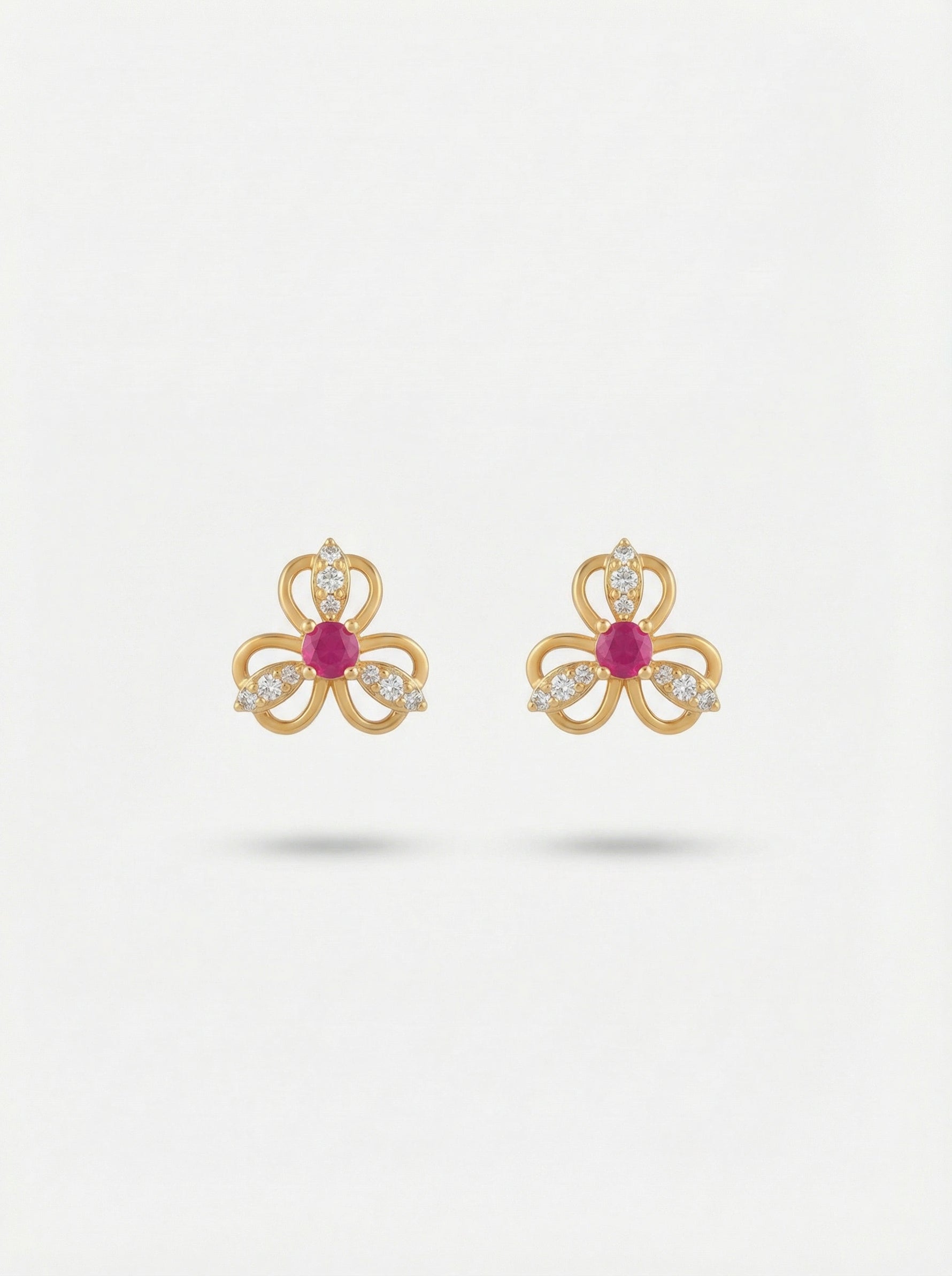 18k Gold plated bow-shaped earrings with red gemstones on a white background