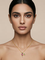 Woman wearing a 18k gold plated necklace with a colorful pendant against a beige background