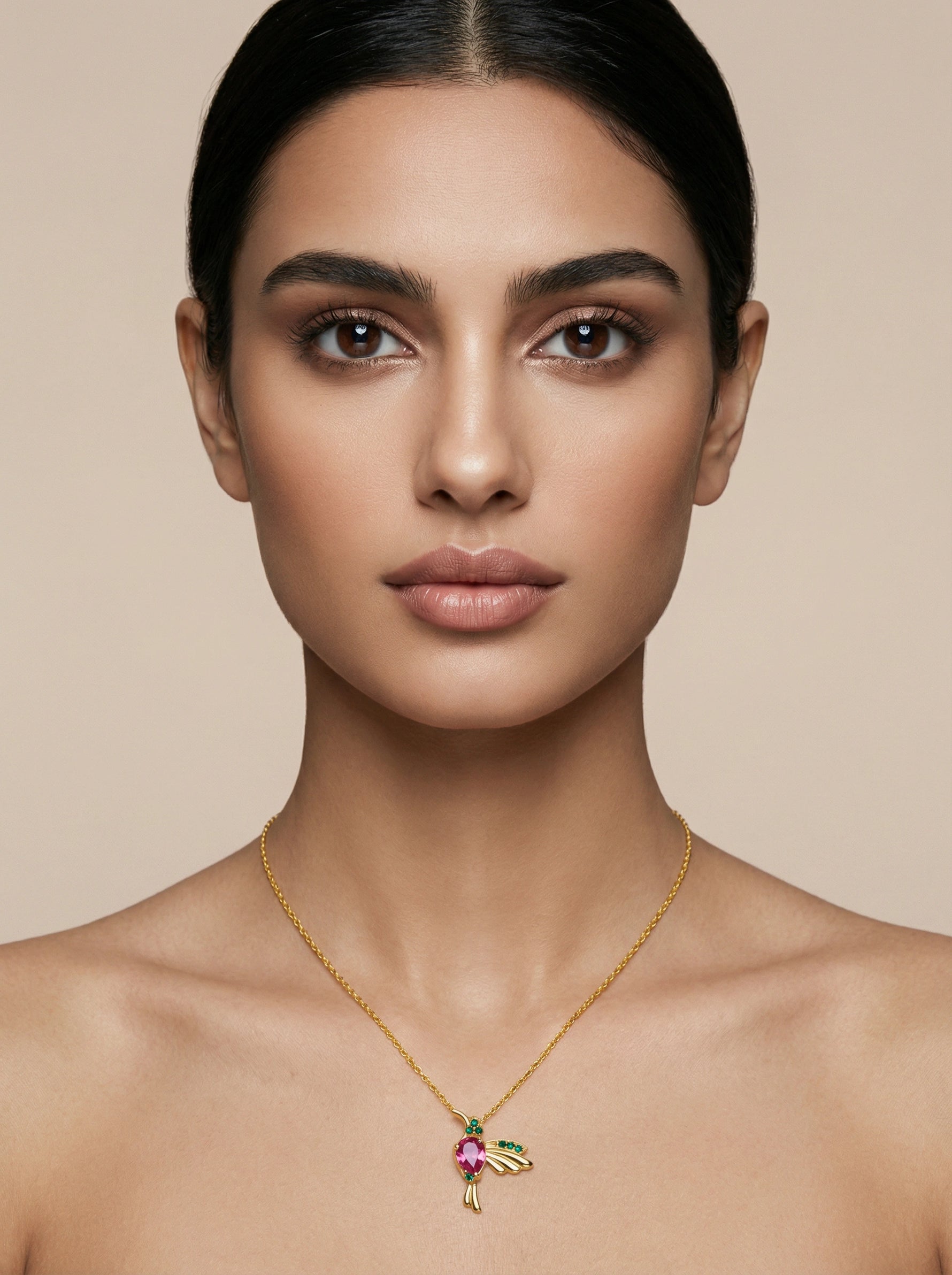 Woman wearing a 18k gold plated necklace with a colorful pendant against a beige background