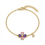 18k Gold plated bracelet with a cross charm featuring pink and purple stones on a white background