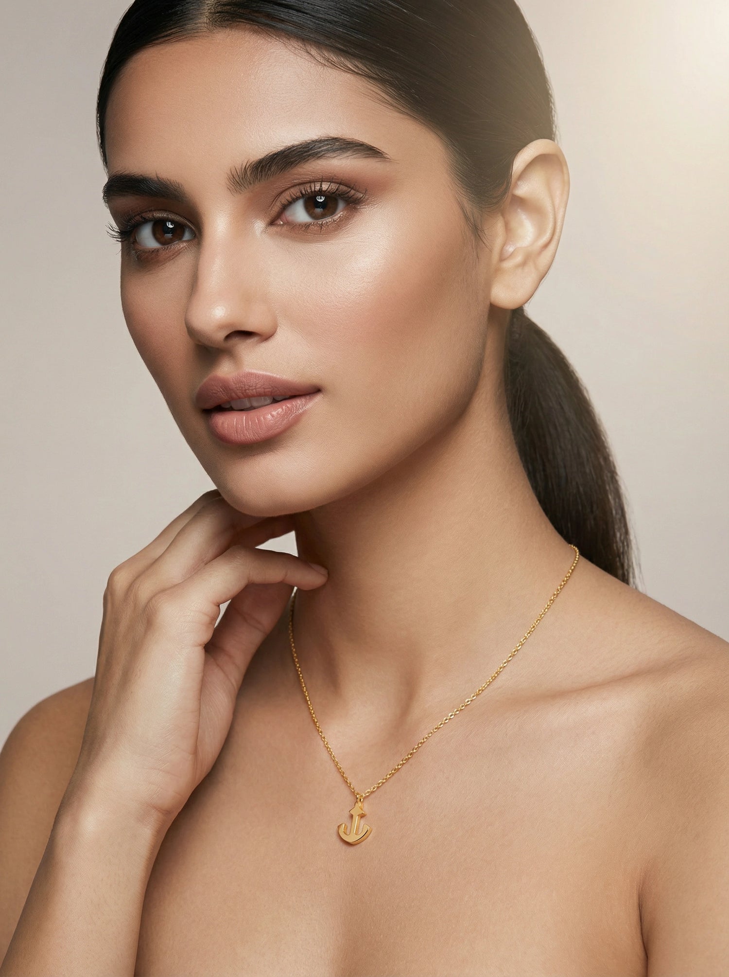 Woman wearing a 18k gold plated necklace with a heart pendant against a neutral background