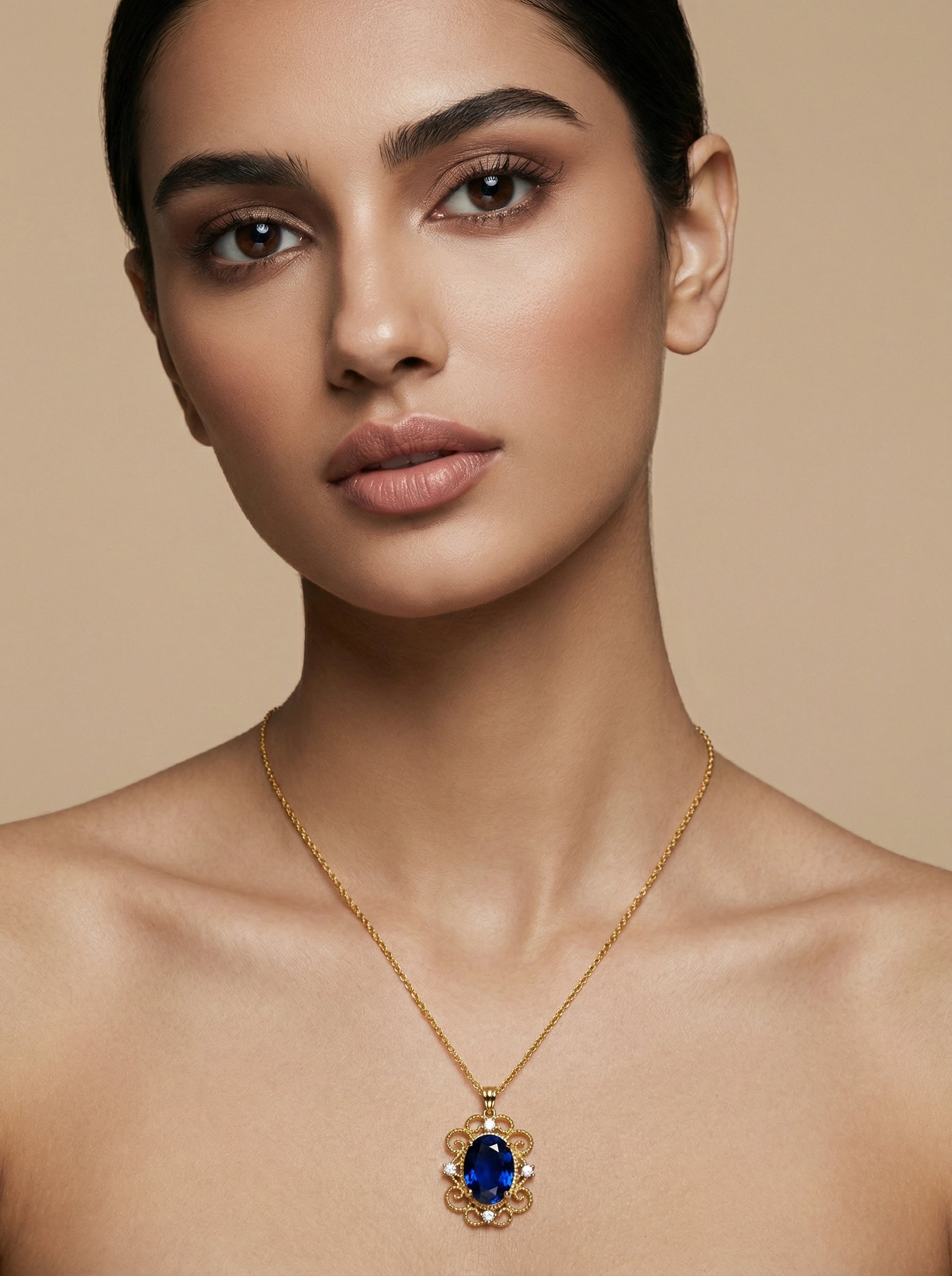 Woman wearing a 18k  gold plated  necklace with a blue gemstone pendant against a beige background