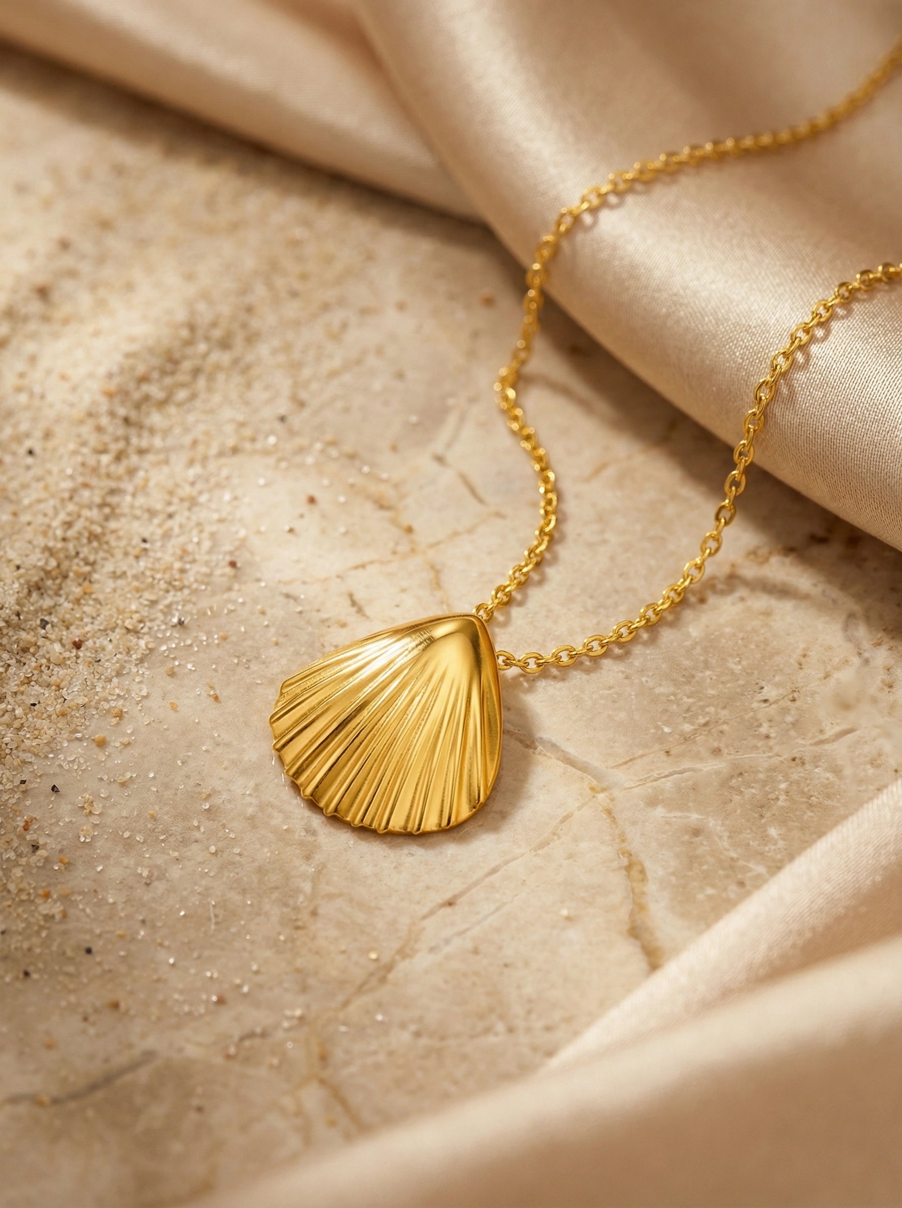 18k Gold plated necklace with a shell pendant on a beige fabric background
