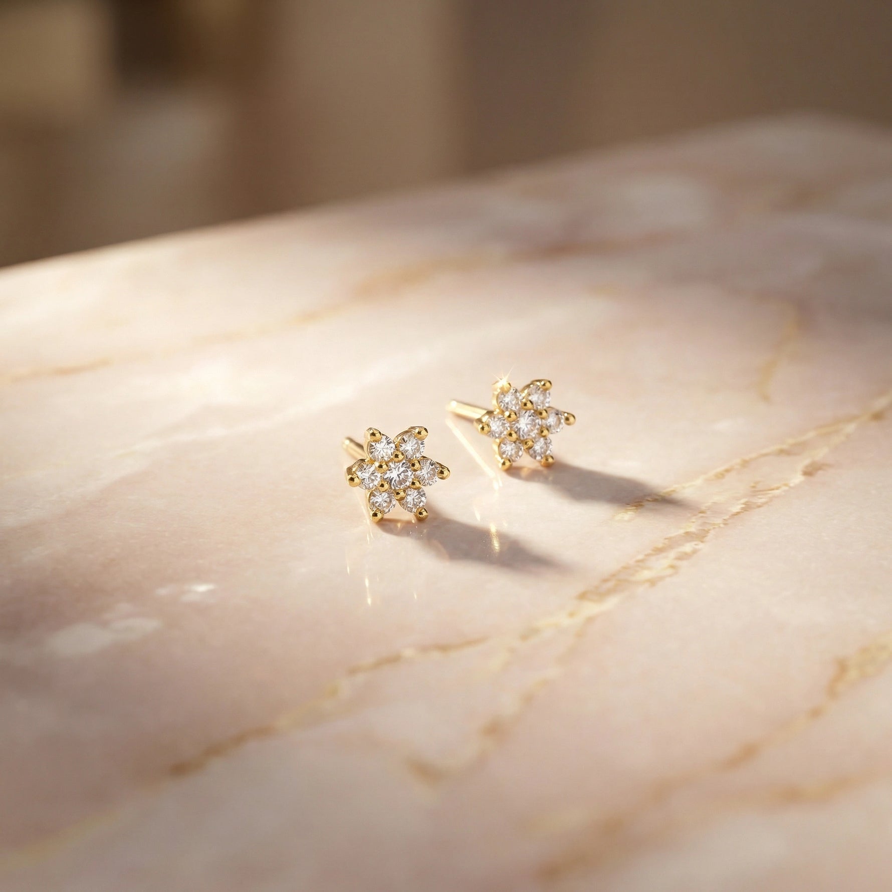 18k Gold plated floral earrings on a marble surface